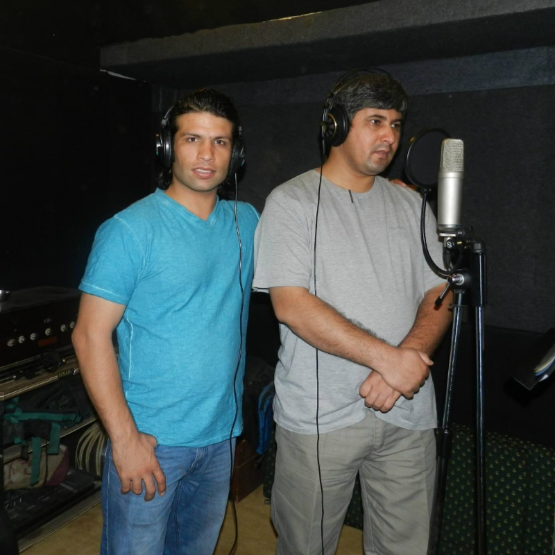 Adib and Obed standing in front of a recording microphone
